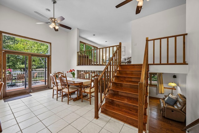 dining area featuring a ceiling fan, stairs, and light tile patterned flooring