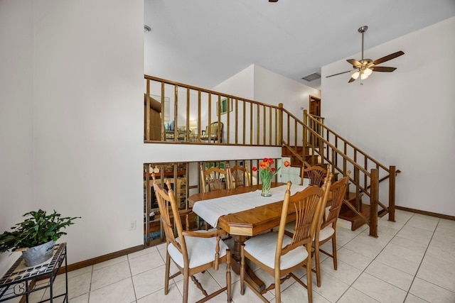 dining room with a ceiling fan, light tile patterned flooring, stairway, and baseboards