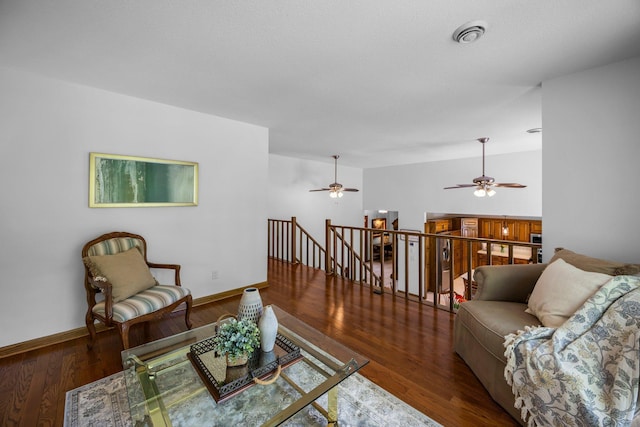 living area featuring a ceiling fan, wood finished floors, and baseboards