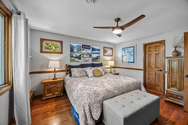 bedroom featuring a textured ceiling, wood finished floors, a ceiling fan, and baseboards