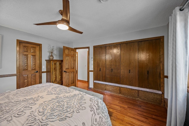 bedroom featuring wood finished floors, a textured ceiling, a closet, and a ceiling fan