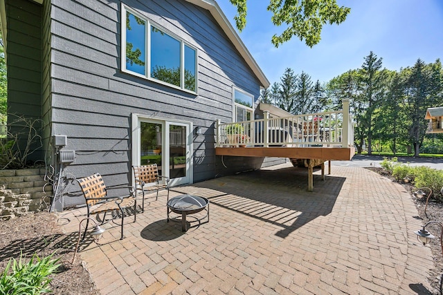 view of patio featuring a wooden deck and an outdoor fire pit