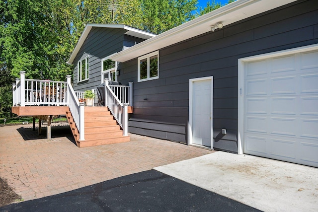 view of property exterior featuring a garage and a wooden deck