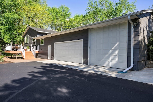 view of property exterior with a garage and a deck