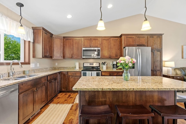 805 Cologne Ln, Waverly, MN 55390 - kitchen featuring appliances with stainless steel finishes, a sink, vaulted ceiling, light wood-type flooring, and a kitchen island