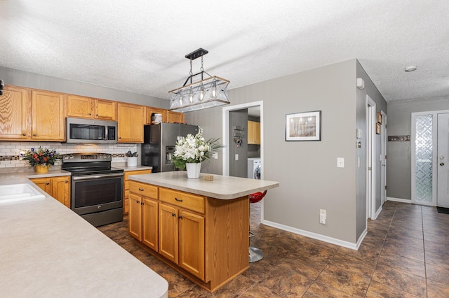 5921 200th St W, Farmington, MN 55024 - kitchen featuring appliances with stainless steel finishes, light countertops, a textured ceiling, decorative backsplash, and washer / clothes dryer
