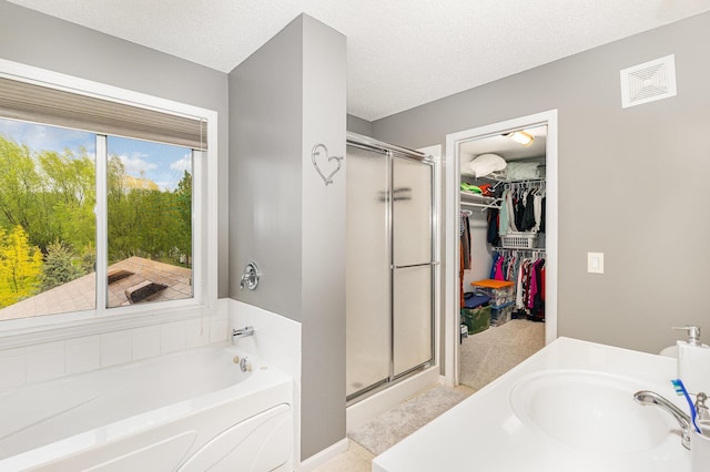 5921 200th St W, Farmington, MN 55024 - full bathroom with a stall shower, a garden tub, a spacious closet, and a textured ceiling