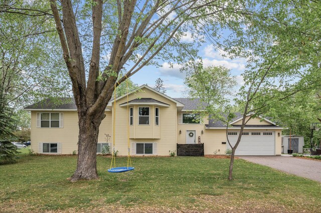 1002 8th Ave N, Princeton, MN 55371 - split level home with driveway, a front lawn, and an attached garage