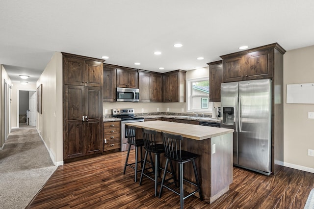 1002 8th Ave N, Princeton, MN 55371 - kitchen featuring appliances with stainless steel finishes, dark brown cabinets, baseboards, dark wood-type flooring, and recessed lighting