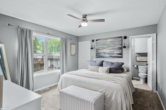 1002 8th Ave N, Princeton, MN 55371 - bedroom with baseboards, light colored carpet, a textured ceiling, connected bathroom, and a ceiling fan