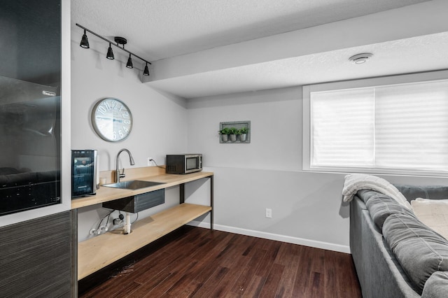 1002 8th Ave N, Princeton, MN 55371 - office space featuring a sink, track lighting, dark wood-style flooring, a textured ceiling, and baseboards