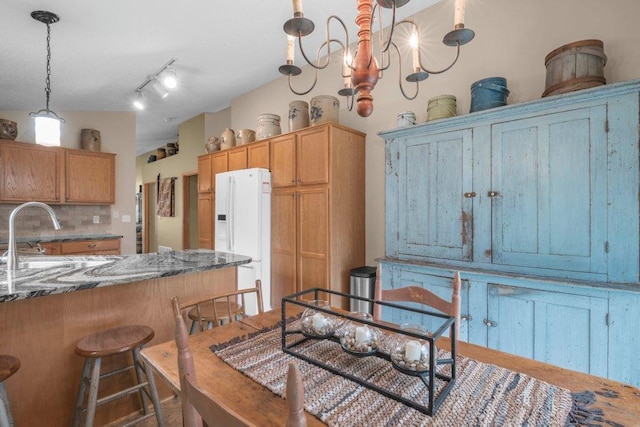 11419 17th St NE, Saint Michael, MN 55376 - kitchen with white refrigerator with ice dispenser, a sink, backsplash, hanging light fixtures, and dark stone countertops