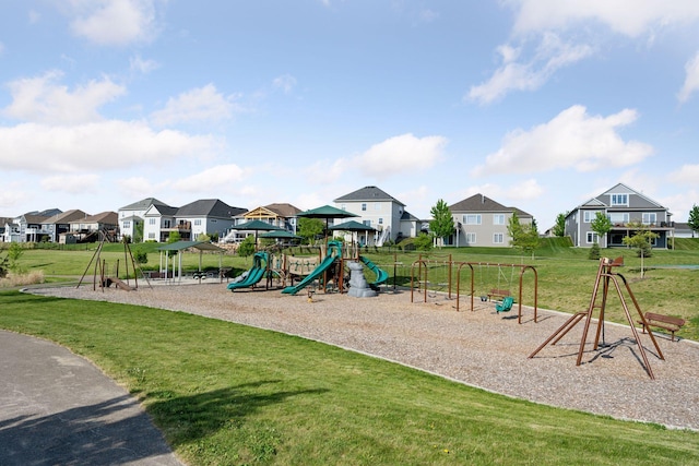 communal playground featuring a residential view and a lawn