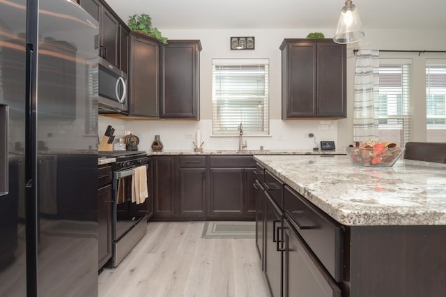 304 Rum River Way, Anoka, MN 55303 - kitchen featuring appliances with stainless steel finishes, a sink, light wood-type flooring, dark brown cabinetry, and light stone countertops