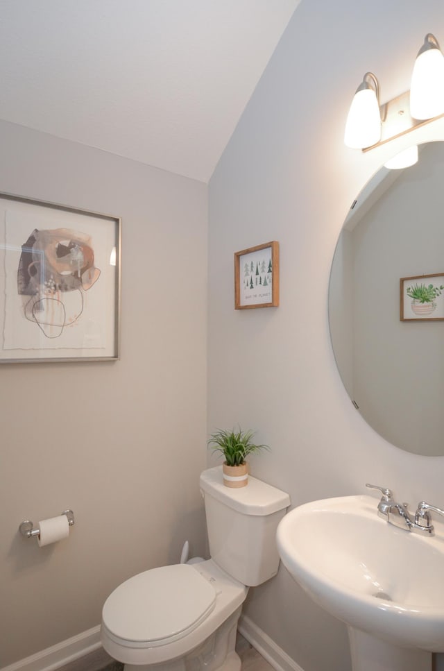 304 Rum River Way, Anoka, MN 55303 - bathroom featuring a sink, toilet, baseboards, and vaulted ceiling