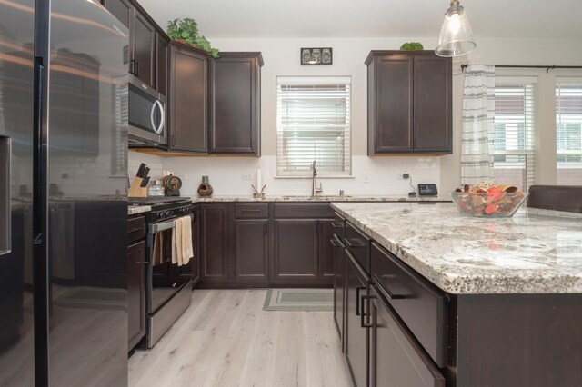 304 Rum River Way, Anoka, MN 55303 - kitchen with appliances with stainless steel finishes, a sink, light wood-style flooring, dark brown cabinetry, and light stone countertops