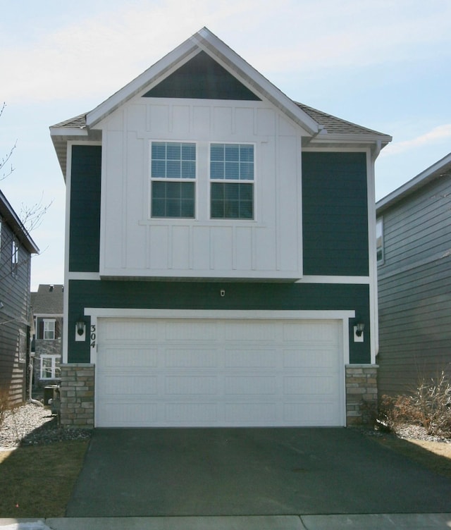304 Rum River Way, Anoka, MN 55303 - view of front facade featuring board and batten siding, stone siding, a garage, and driveway