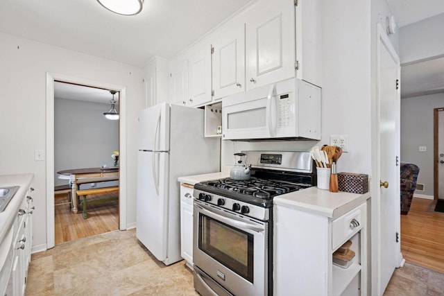 kitchen featuring white appliances, white cabinets, and light countertops