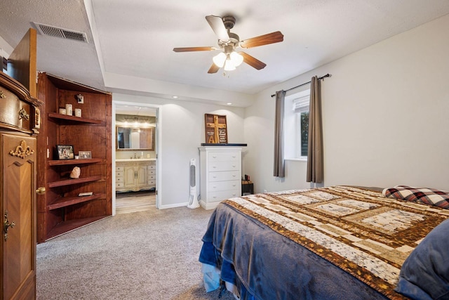 carpeted bedroom featuring ensuite bathroom, ceiling fan, and a sink
