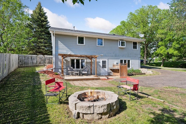 rear view of property with a pergola, an outdoor fire pit, and a patio area