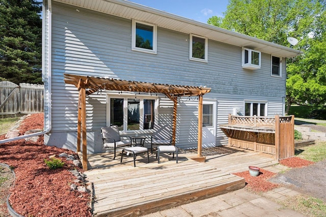 back of property with a deck and fence