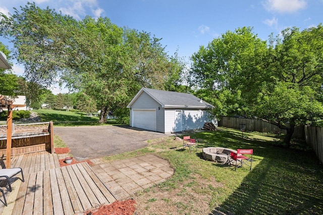 view of yard with an outbuilding, an outdoor fire pit, a detached garage, and a deck