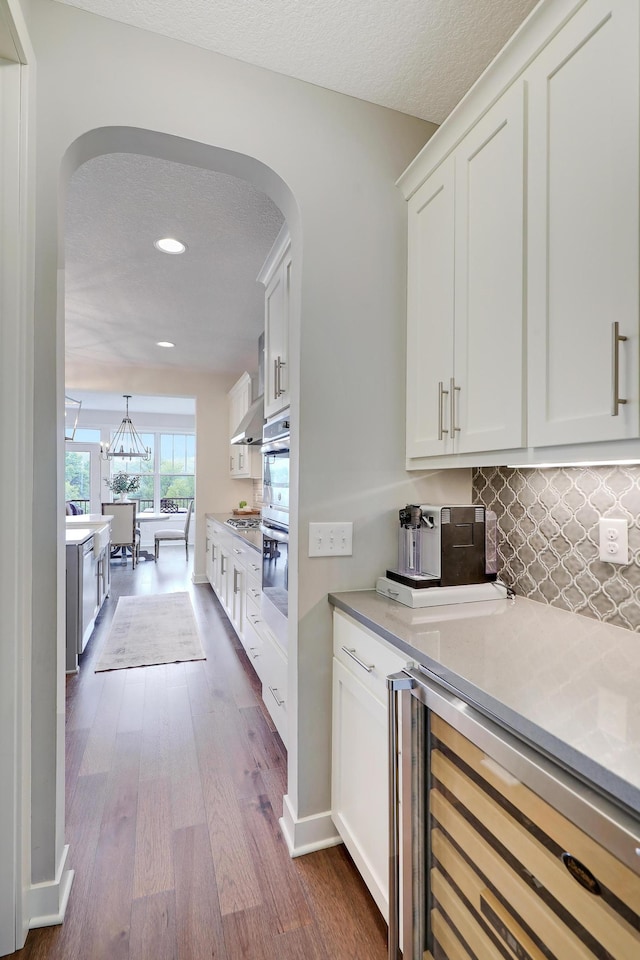 14778 50th St NE, Saint Michael, MN 55376 - kitchen with wine cooler, arched walkways, ventilation hood, dark wood-type flooring, and recessed lighting