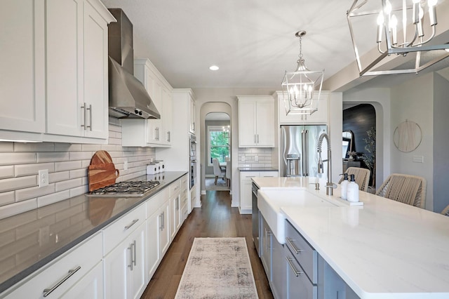 14778 50th St NE, Saint Michael, MN 55376 - kitchen featuring arched walkways, a chandelier, wall chimney range hood, appliances with stainless steel finishes, and recessed lighting
