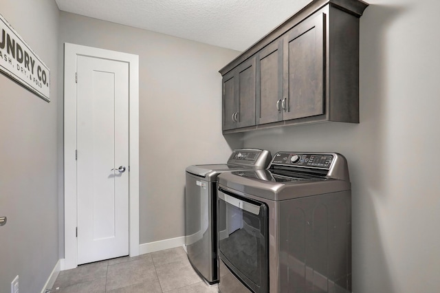 14778 50th St NE, Saint Michael, MN 55376 - washroom featuring washing machine and dryer, cabinet space, light tile patterned floors, baseboards, and a textured ceiling