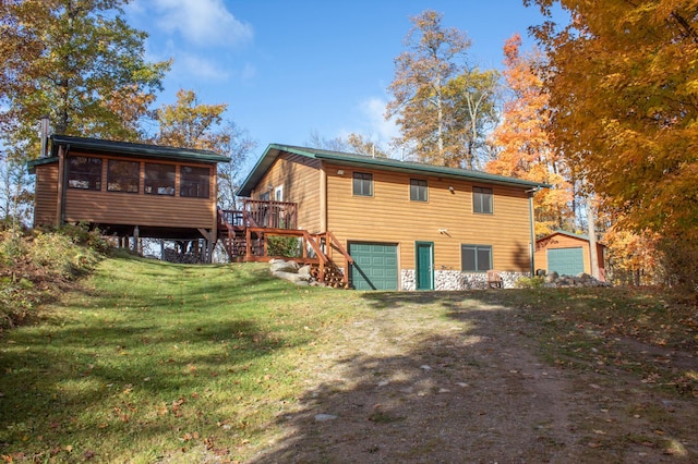 1910 Longwood Point Rd NE, Outing, MN 56662 - back of property with a sunroom, an attached garage, stairway, a lawn, and dirt driveway