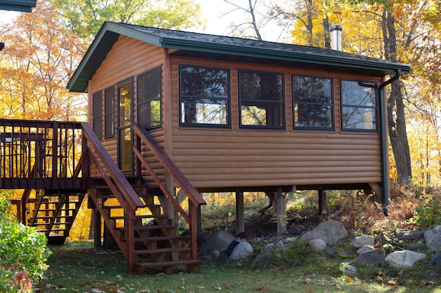 1910 Longwood Point Rd NE, Outing, MN 56662 - view of property exterior featuring log veneer siding, stairway, and a sunroom