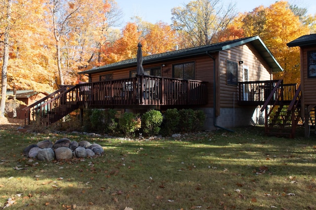 1910 Longwood Point Rd NE, Outing, MN 56662 - rear view of property featuring stairway, a deck, a lawn, and faux log siding
