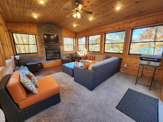 1910 Longwood Point Rd NE, Outing, MN 56662 - living room with vaulted ceiling, healthy amount of natural light, a ceiling fan, a fireplace, and wooden walls