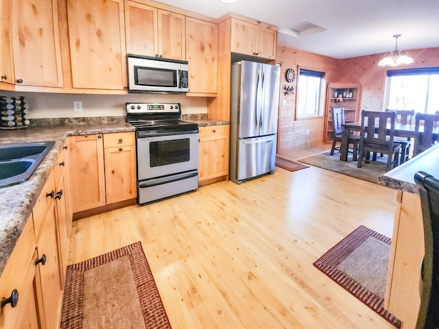 1910 Longwood Point Rd NE, Outing, MN 56662 - kitchen featuring stainless steel appliances, light brown cabinets, light wood finished floors, and a chandelier