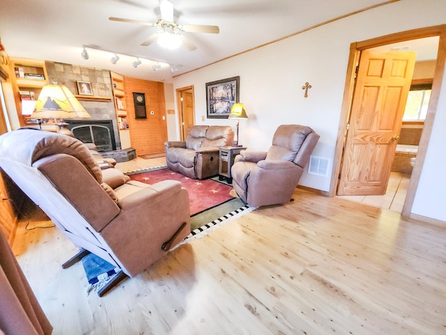 1910 Longwood Point Rd NE, Outing, MN 56662 - living area featuring wood finished floors, a ceiling fan, a fireplace, and baseboards