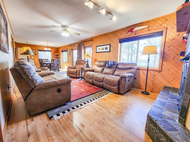 1910 Longwood Point Rd NE, Outing, MN 56662 - living room with wooden walls, wood finished floors, a ceiling fan, and track lighting
