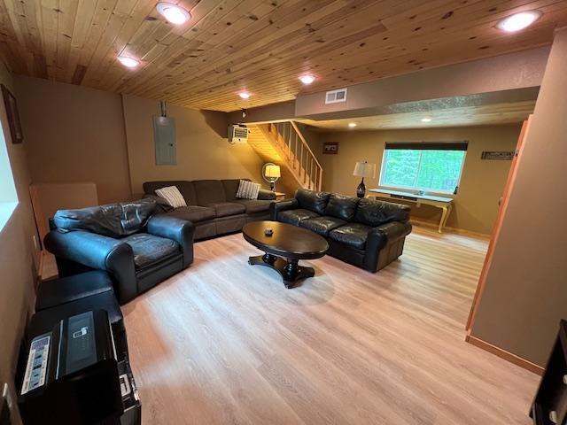 1910 Longwood Point Rd NE, Outing, MN 56662 - living room with stairs, light wood-type flooring, electric panel, wooden ceiling, and baseboards