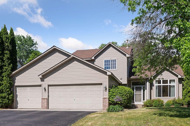 1780 Quail Dr, Shakopee, MN 55379 - traditional-style home with an attached garage, brick siding, asphalt driveway, and a front yard