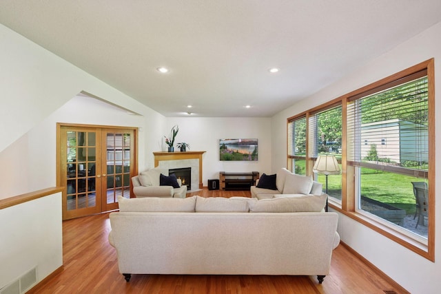 1780 Quail Dr, Shakopee, MN 55379 - living room with french doors, light wood-style floors, a fireplace with flush hearth, recessed lighting, and baseboards