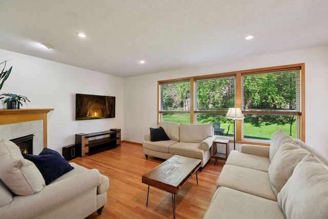 1780 Quail Dr, Shakopee, MN 55379 - living room featuring a textured ceiling, light wood-style floors, a tile fireplace, and recessed lighting