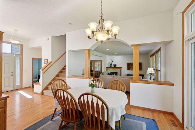 1780 Quail Dr, Shakopee, MN 55379 - dining area featuring light wood finished floors, plenty of natural light, a chandelier, and ornate columns