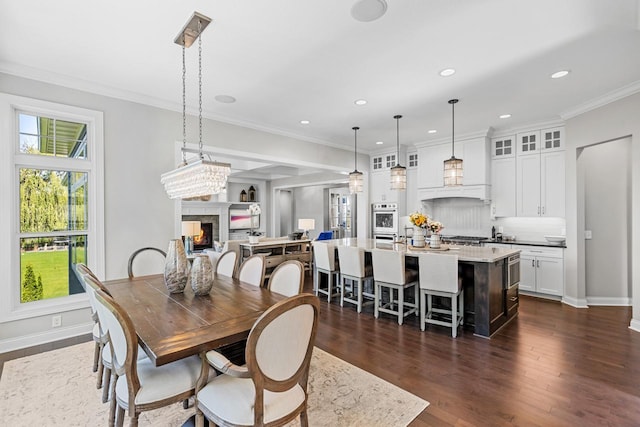 5980 Prestwick Ct, Shorewood, MN 55331 - dining room with a warm lit fireplace, dark wood-style flooring, recessed lighting, baseboards, and crown molding