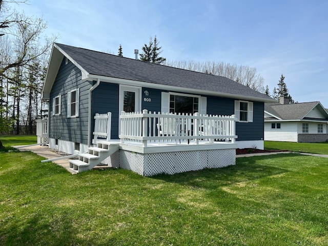 603 Main Ave N, Roseau, MN 56751 - back of property with a deck, a yard, and roof with shingles