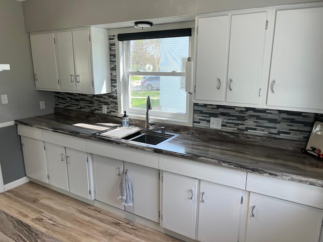 603 Main Ave N, Roseau, MN 56751 - kitchen with dark countertops, a sink, and backsplash