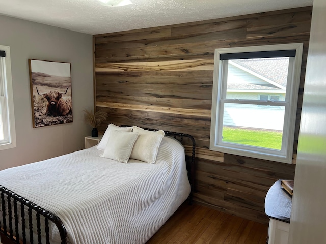 603 Main Ave N, Roseau, MN 56751 - bedroom featuring wooden walls and dark wood-style floors