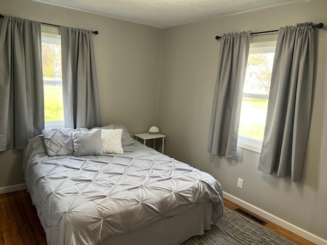 603 Main Ave N, Roseau, MN 56751 - bedroom featuring baseboards, wood finished floors, and multiple windows