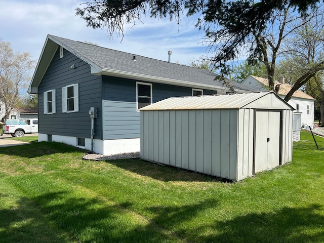 603 Main Ave N, Roseau, MN 56751 - rear view of house with a storage shed, a lawn, an outbuilding, and a shingled roof