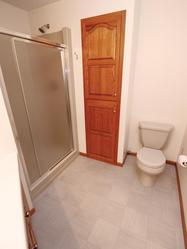 538 Nordic Ln, Troy Twp, WI 54016 - bathroom with a shower stall, toilet, baseboards, and tile patterned floors