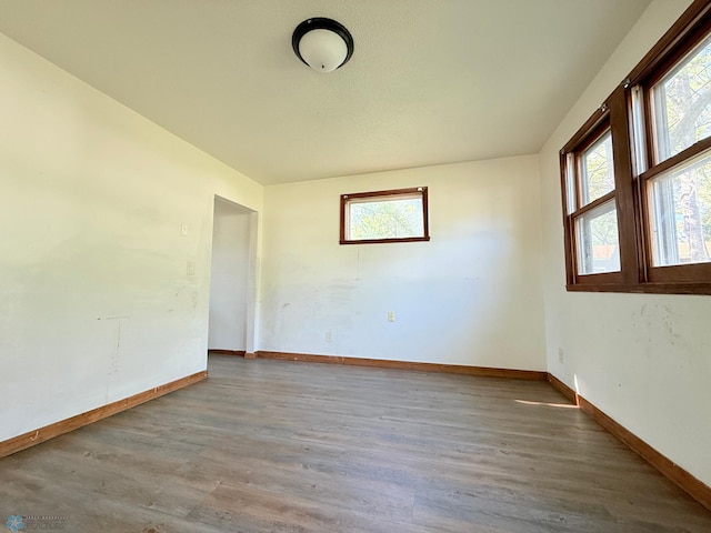 spare room featuring wood finished floors and baseboards