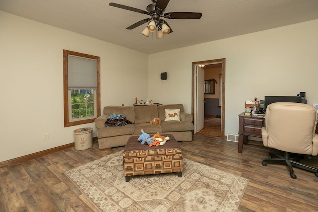 210 1st St SE, Hayfield, MN 55940 - living area featuring wood finished floors, a ceiling fan, baseboards, and a desk